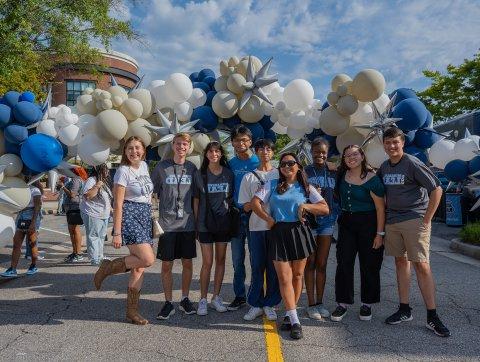 students in odu gear under a balloon arch on monarch way